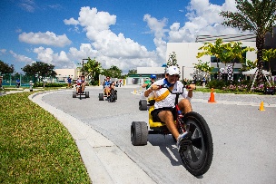 Students racing on the three wheeler bikes at Founders Day